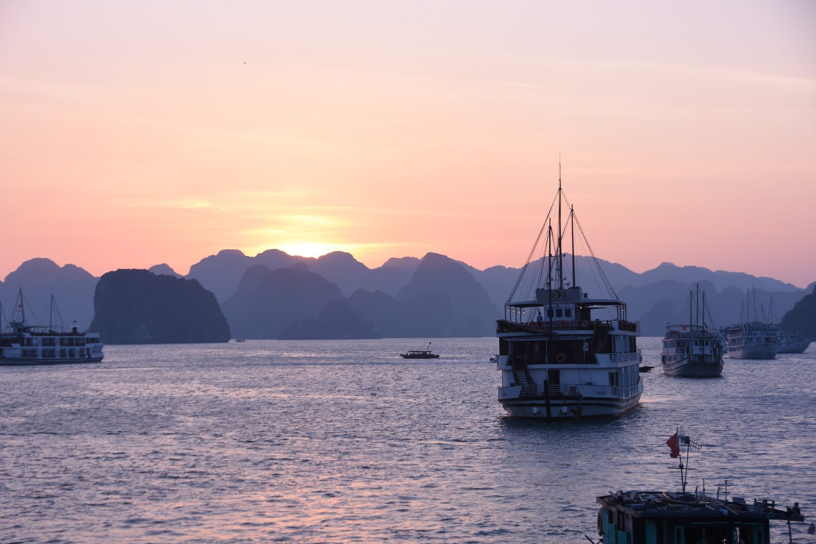 Cruise boats at anchor in Hạ Long Bay at sunset