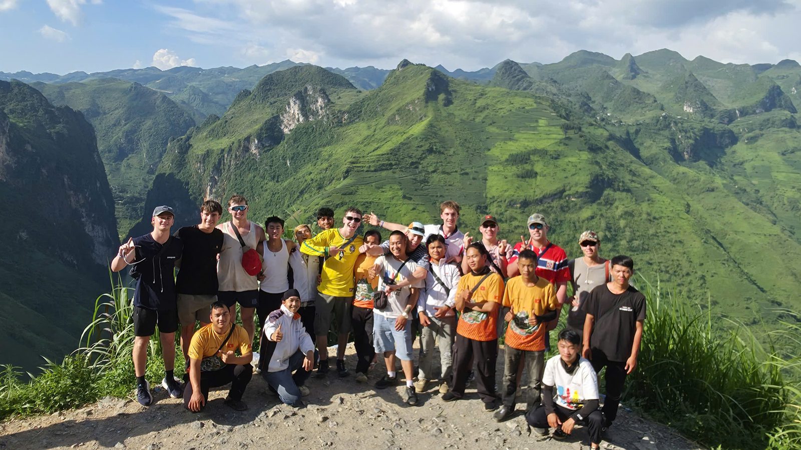 A big group of travellers and their easy riders on a ledge high above karst ridges